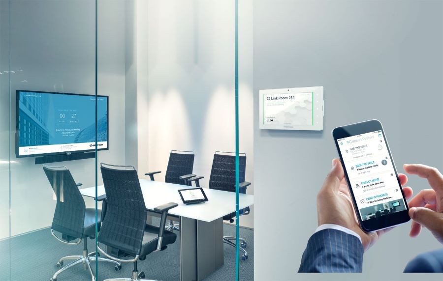 A video conference room and a person holding a smartphone.