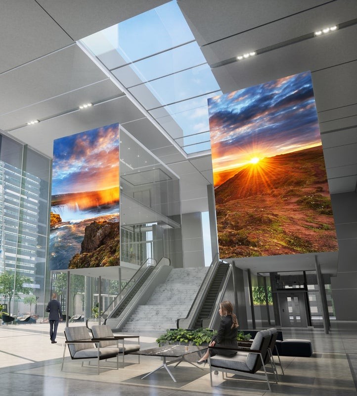 A commercial lobby space featuring two large video walls.