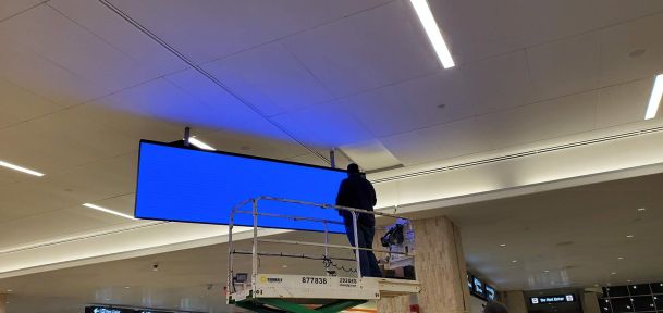 Technician installing a tv hanging from the ceiling