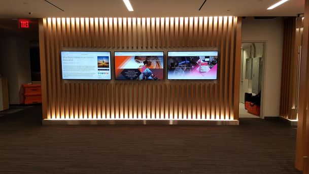 Video wall in a wood panel hall wall